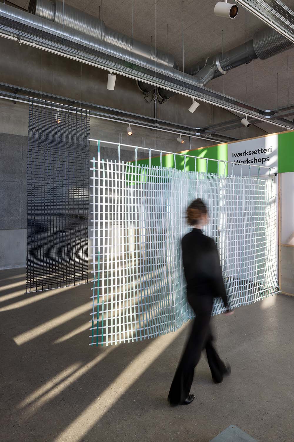 Foto af kvinde foran rumdelere lavet af genbrugsplast